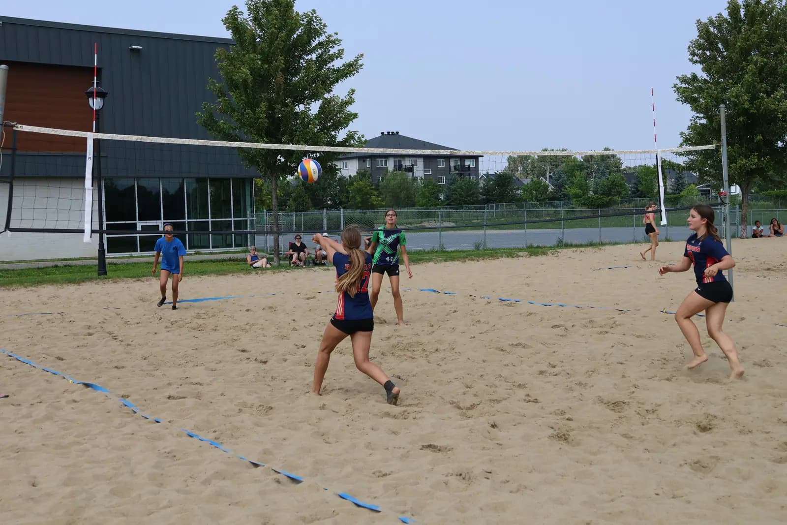 Équipe de jeunes en pleine partie de beach-volleyball